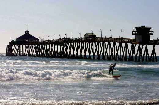 Surfer in front of Imperial Beach Pier in San Diego's South Bay