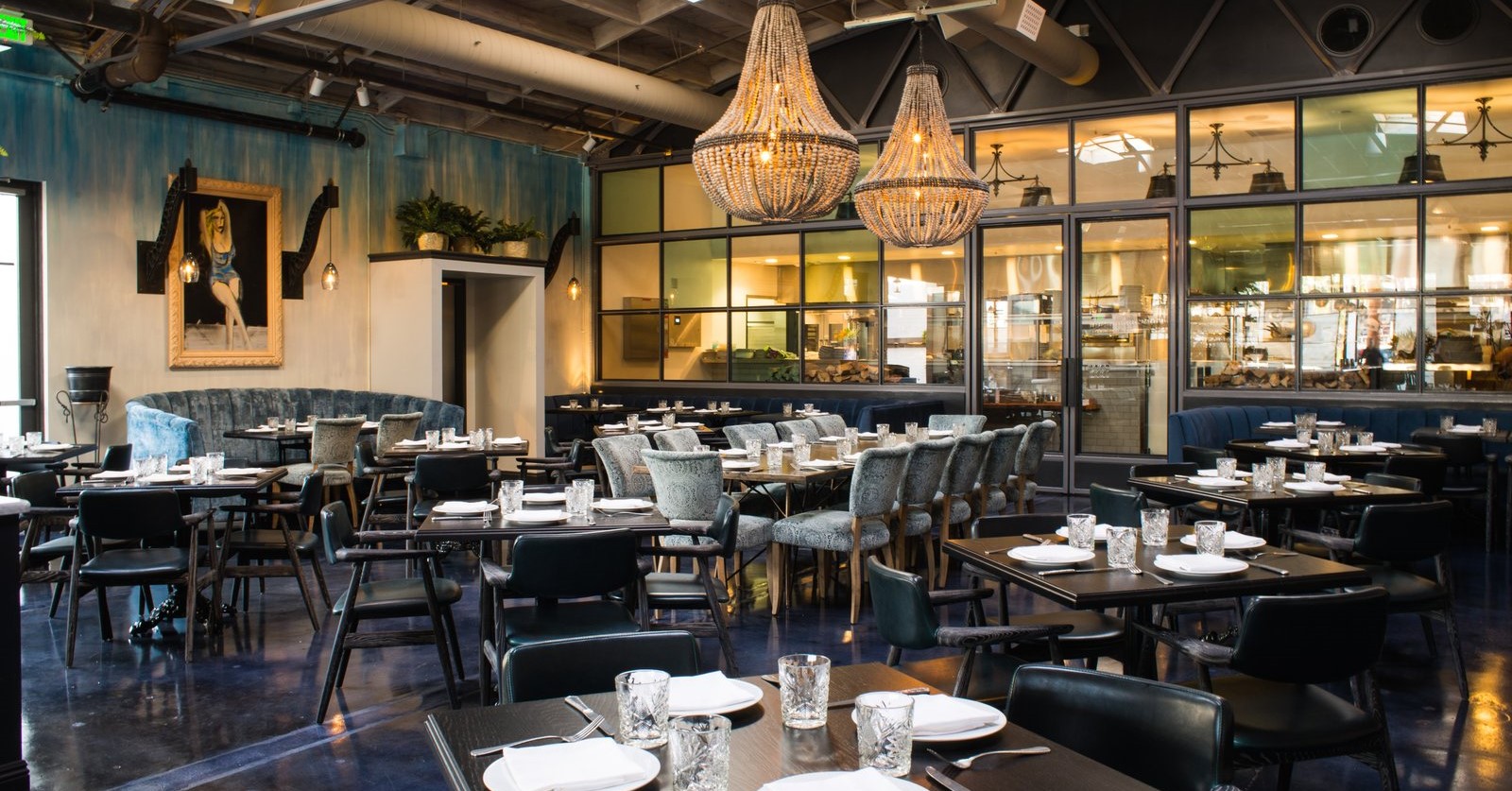 Tables and chairs fill the airy dining room of Herb and Wood restaurant in San Diego.